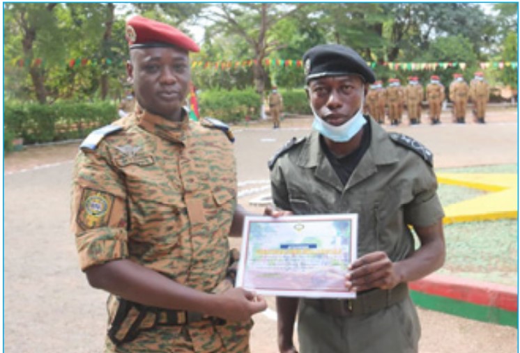 Le Directeur des Etudes, des Evaluations et des Stages (DEES)de l’END, l’inspecteur principal des douanes, Koulibila Etienne NEYA (à gauche) remettant à un élève douanier l’attestation de formation militaire 2021.