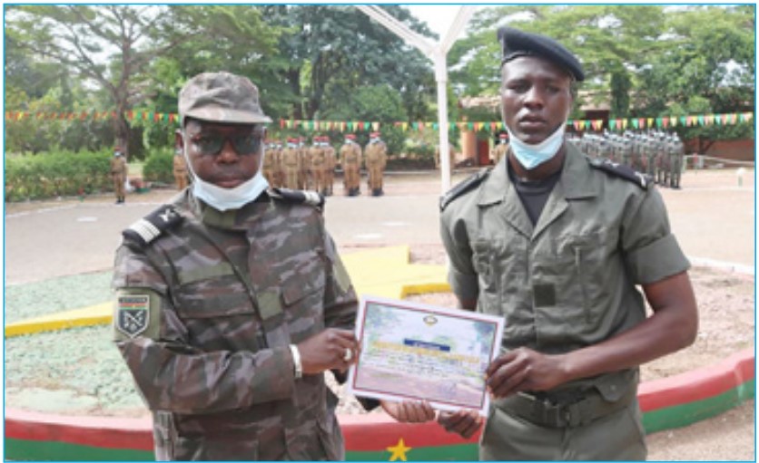 Le Commandant du Groupement d'Instruction des Forces Armées (GIFA) Jean Marie T. SURYOUMA à gauche, remettant l’attestation de formation militaire à un élève douanier de la promotion 2021.